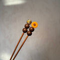 Amigurumi-Stick orangene Blume mit braunen Details